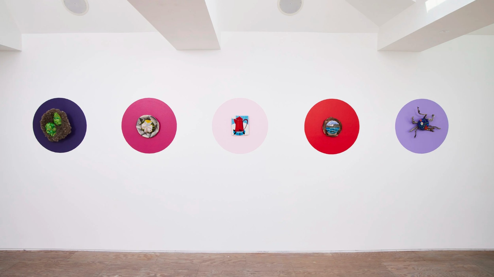 Five works displayed on coloured circles in Nuliaminik Neqilik at Mimosa House, London